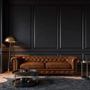 Modern classic black interior with capitone brown leather chester sofa, floor lamp, coffee table, carpet, wood floor, mouldings. 3d render interior mock up.